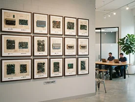 A gallery wall of framed circuit boards in the office